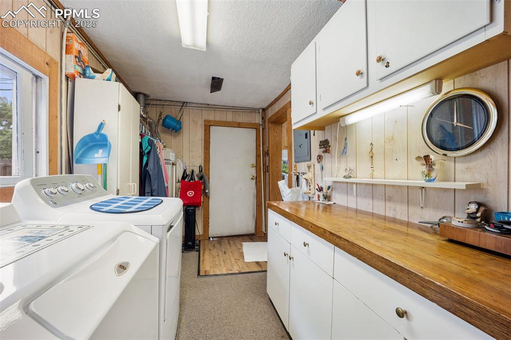 Image 20 of 48: Laundry area with washing machine and clothes dryer, wooden walls, a textur
