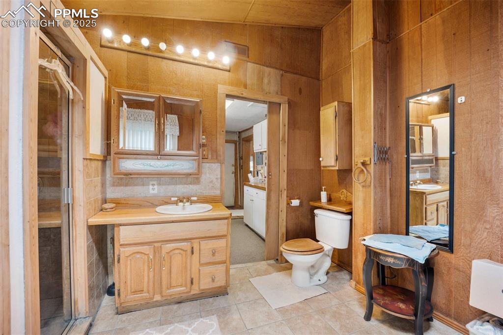 Image 21 of 48: Bathroom with tile patterned flooring and vanity