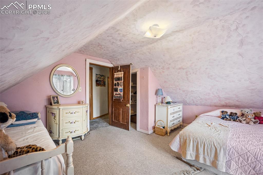 Image 31 of 48: Carpeted bedroom featuring vaulted ceiling and a textured ceiling