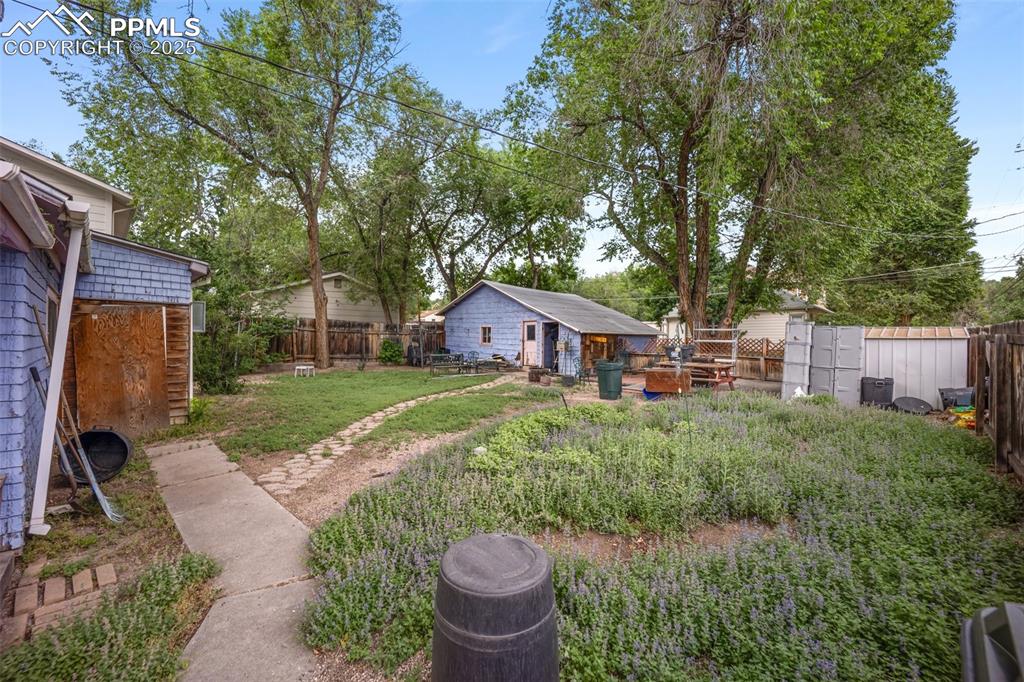 Image 35 of 48: Fenced backyard featuring an outdoor structure