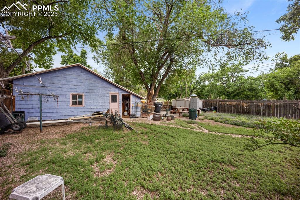 Image 5 of 48: Fenced backyard with a storage unit