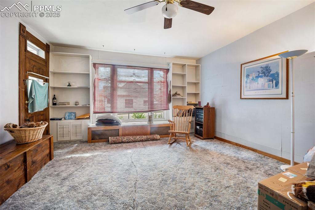 Image 9 of 48: Living area with plenty of natural light, a ceiling fan, and carpet floors