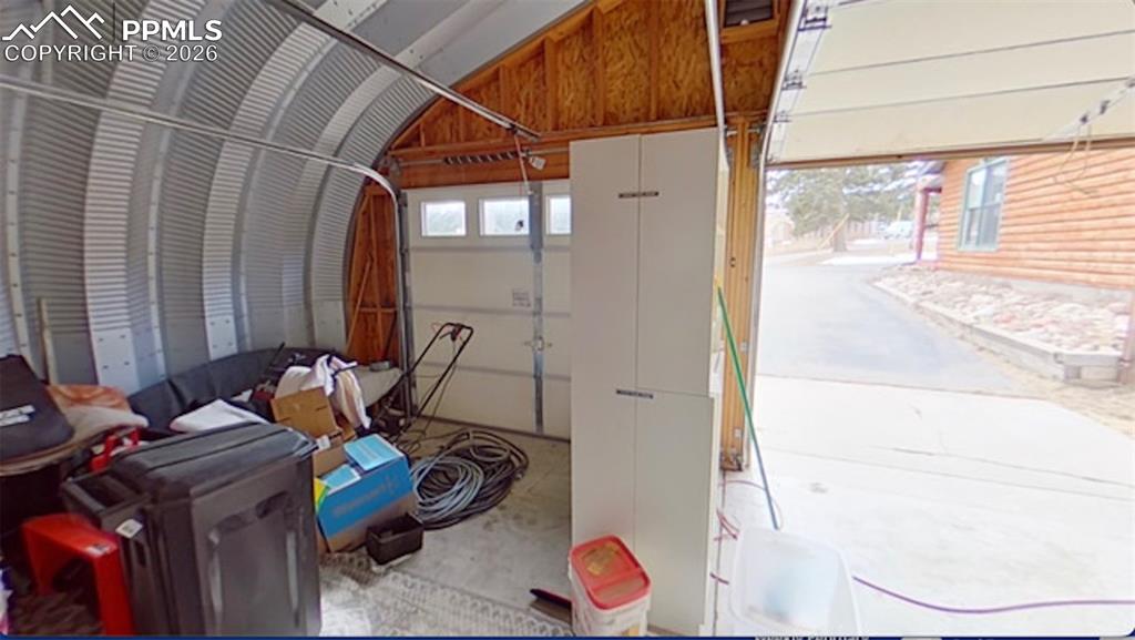 Image 29 of 38: Back of home with garage to the left