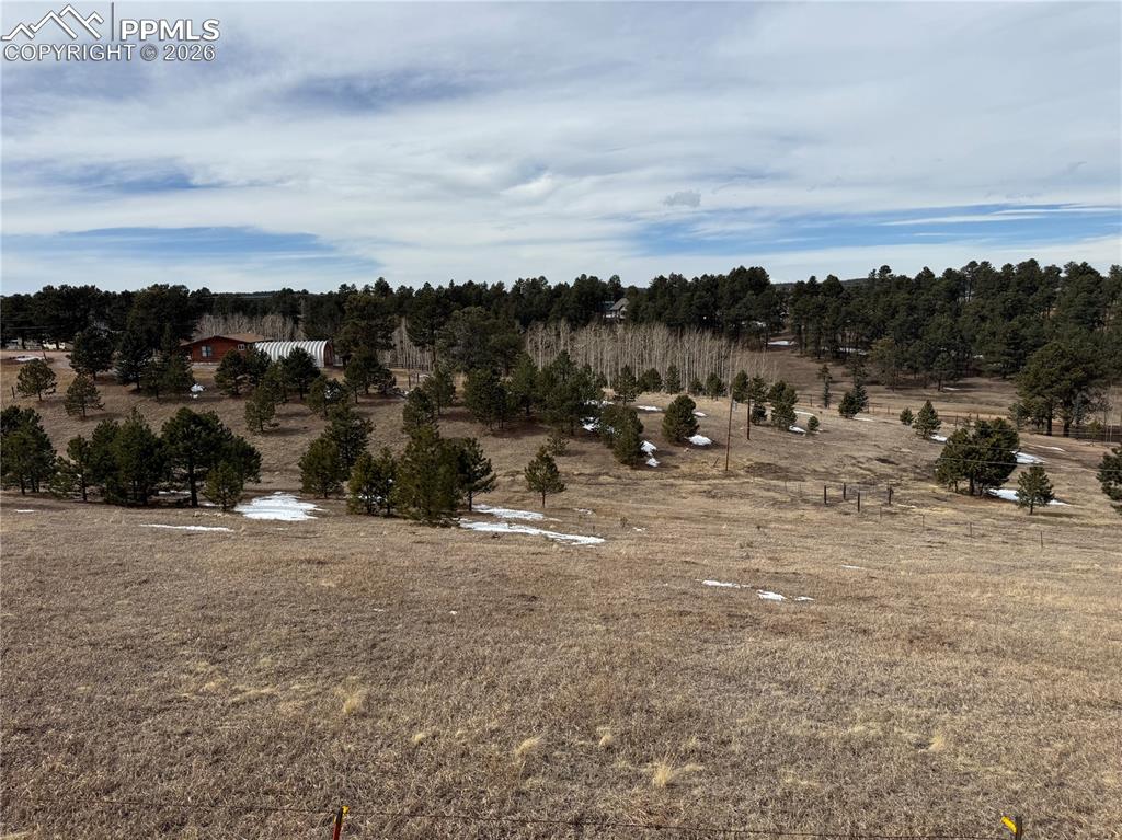 Image 38 of 38: Fenced land with home on the horizon