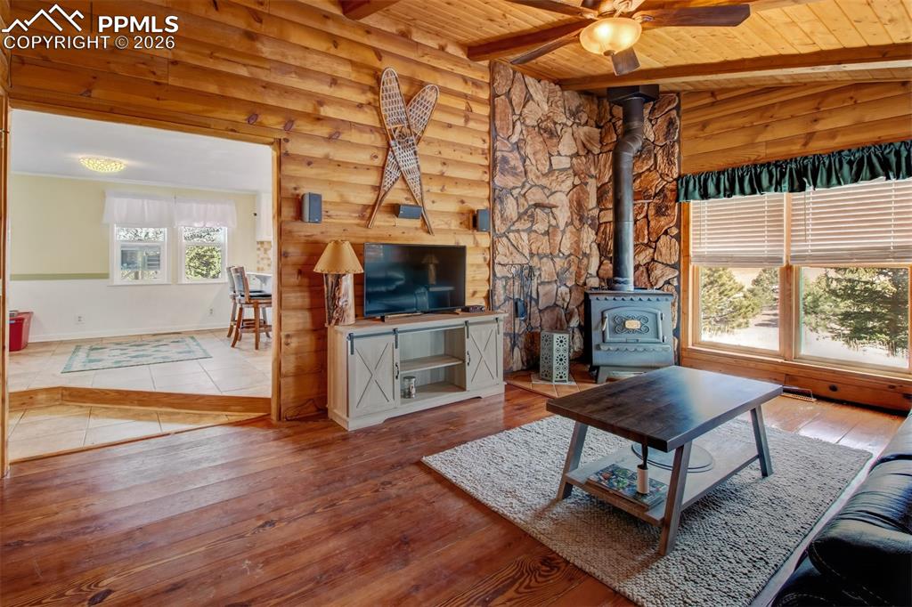 Image 4 of 38: Living wood with wood burning stove, wood accents all around and wood floor