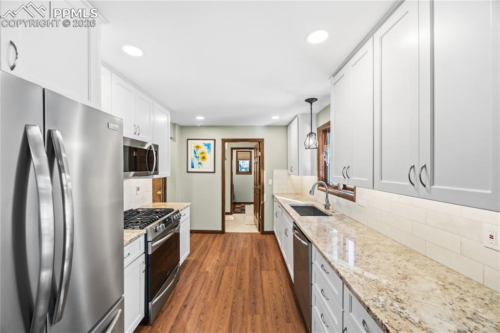 Image 10 of 40: granite countertops, gas stove, under cabinet lighting, soft close doors