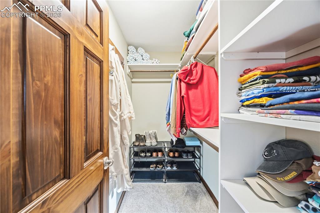 Image 20 of 40: primary walk-in closet with built-in organizers