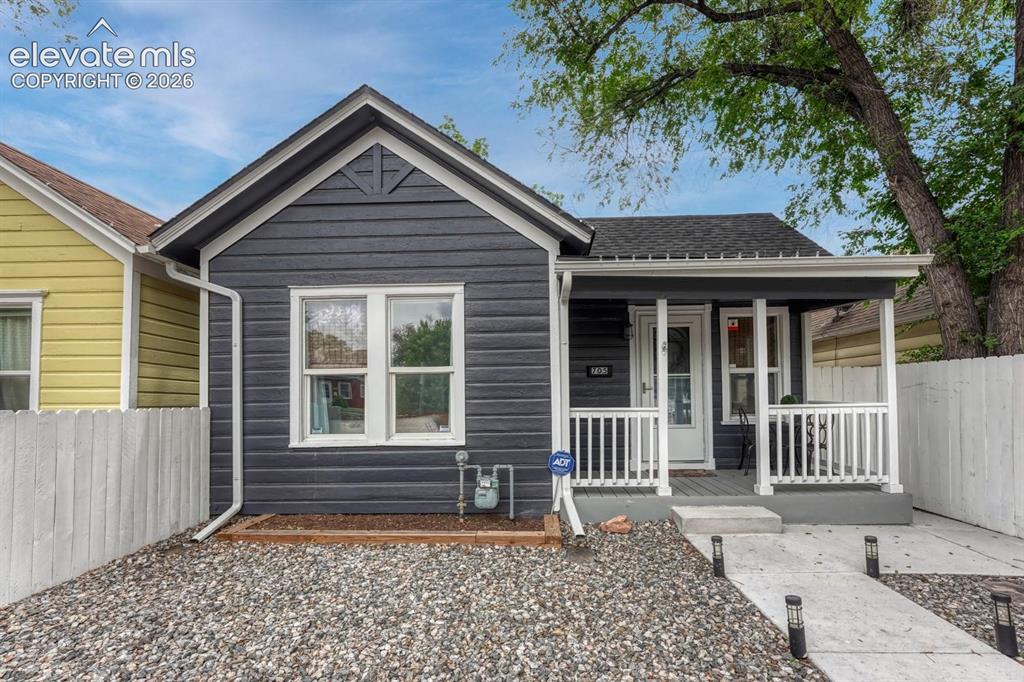 Image 1 of 21: Modern bungalow exterior featuring dark horizontal siding, white trim, a co