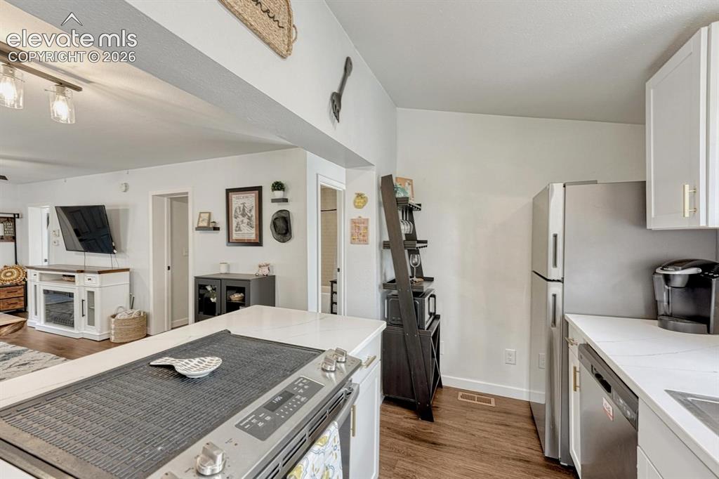 Image 10 of 21: Modern kitchen featuring white quartz countertops, cabinetry, stainless ste