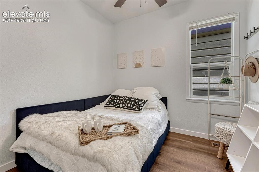 Image 11 of 25: Wood-finish flooring throughout, bright white walls, and a window with blin