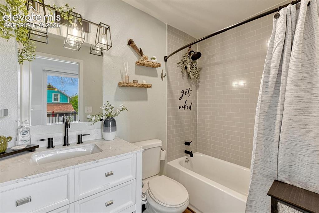 Image 13 of 21: Bathroom featuring a white vanity with a quartz countertop and undermount s