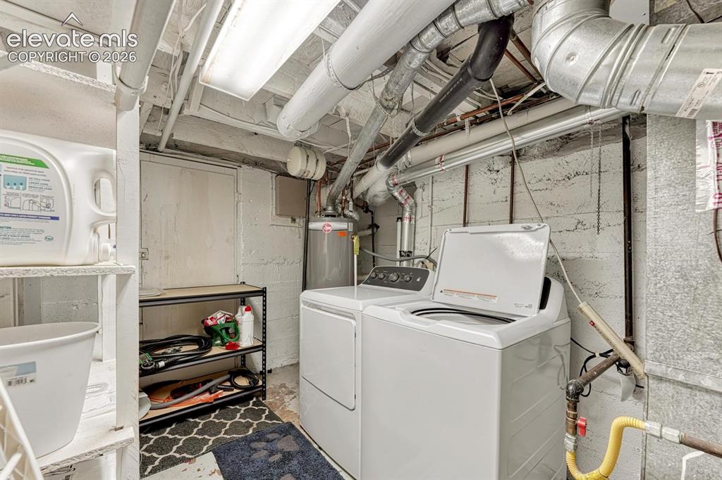 Image 19 of 21: Utility area featuring laundry appliances, exposed plumbing, and overhead f