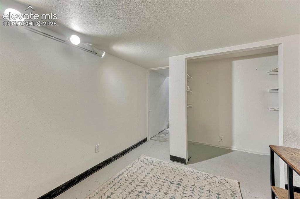 Image 21 of 21: Recessed open shelving within a dedicated alcove, complemented by track lig