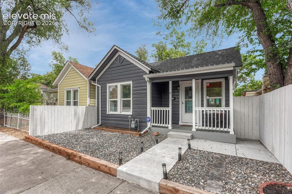 Image 3 of 21: Dark gray siding exterior with white trim and a covered front porch featuri