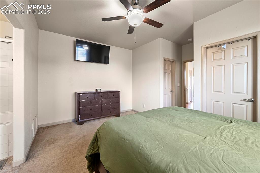 Image 12 of 22: Bedroom with ceiling fan, baseboards, and light colored carpet