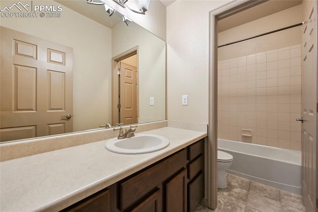 Image 17 of 22: Bathroom featuring toilet, vanity, and shower / tub combination