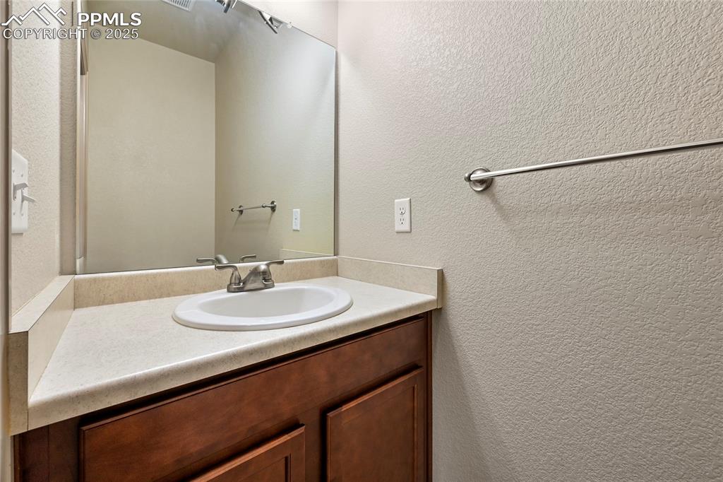 Image 20 of 22: Bathroom featuring a textured wall and vanity