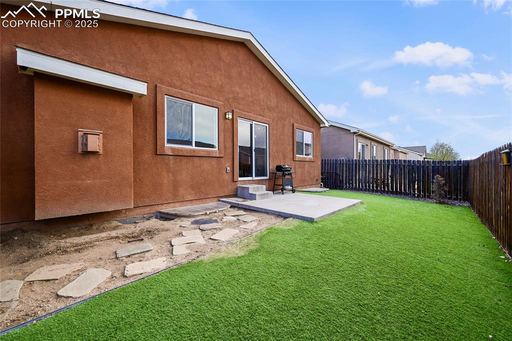 Image 21 of 22: Rear view of property with a patio area, a lawn, a fenced backyard, and stu