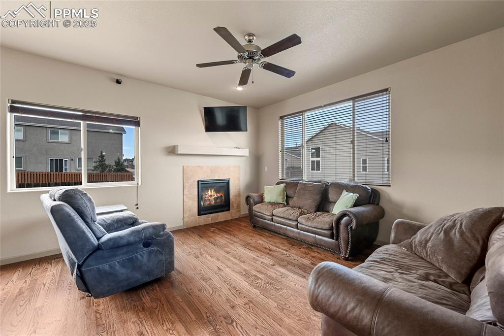 Image 4 of 22: Living room with a fireplace, wood finished floors, baseboards, and ceiling