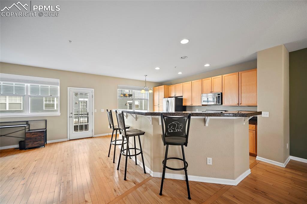 Image 8 of 49: Breakfast bar in open floor plan. Walk out to the balcony. Great for your B