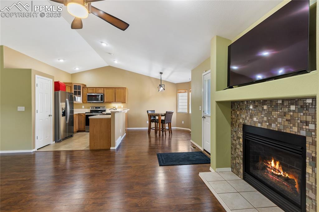 Image 11 of 36: Kitchen with glass fronted cabinets, wood finish cabinetry, open floor plan