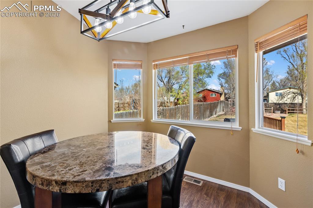 Image 16 of 36: Dining room with a chandelier, wood finished floors, and a textured wall