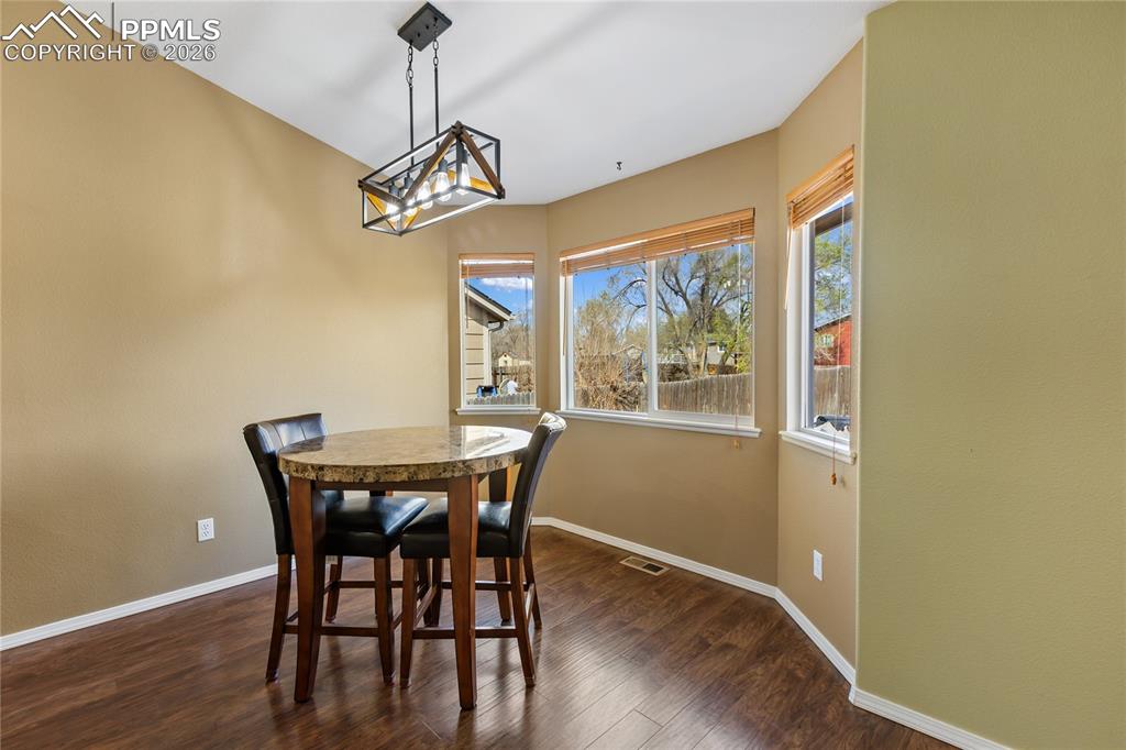 Image 18 of 36: Dining area featuring dark wood-style flooring and plenty of natural light