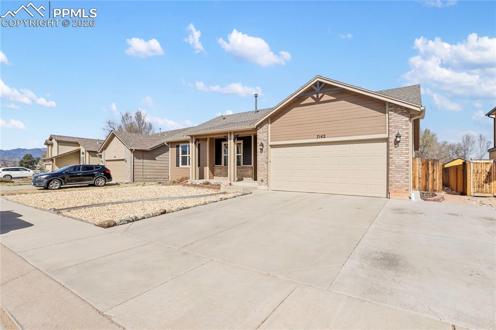 Image 3 of 36: Ranch-style house featuring a garage, concrete driveway, and brick siding