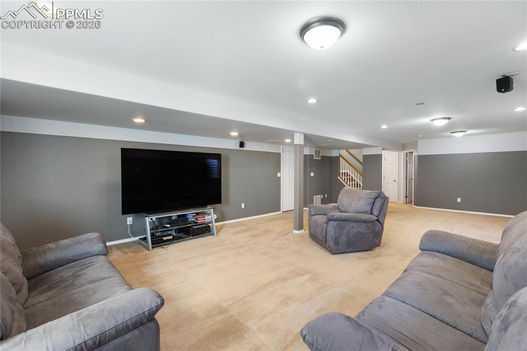 Image 34 of 36: Living room with light colored carpet and recessed lighting