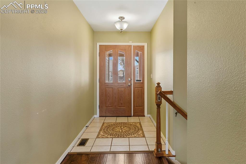 Image 6 of 36: Entryway with a textured wall and tile patterned floors