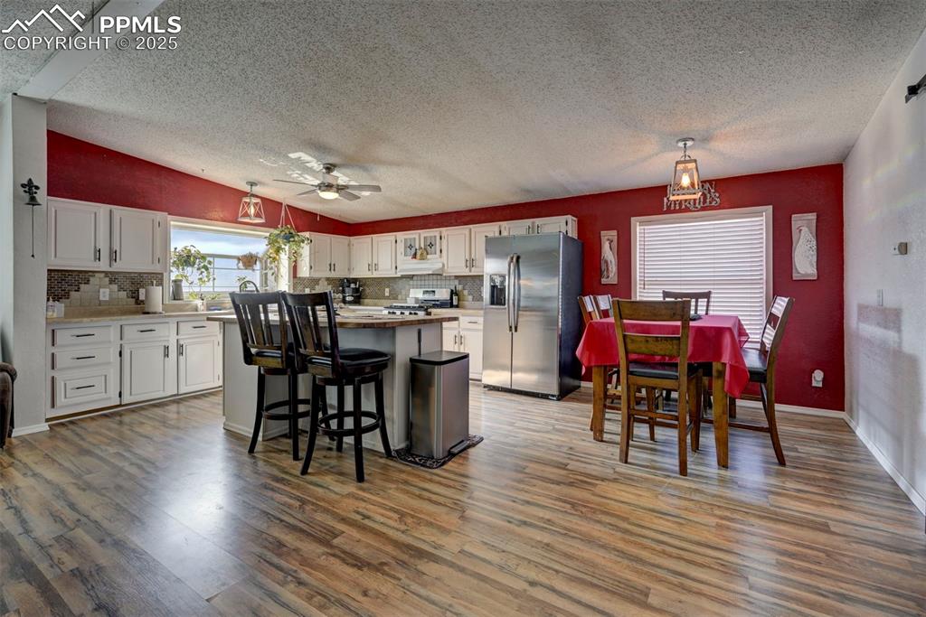 Image 10 of 31: Kitchen with white cabinets, stainless steel appliances, a textured ceiling