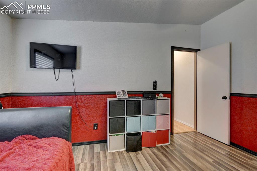 Image 29 of 31: Bedroom with wood finished floors and a textured ceiling