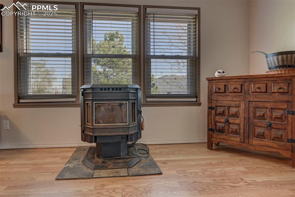 Image 8 of 31: Detailed view of a wood stove, wood finished floors, and a textured wall