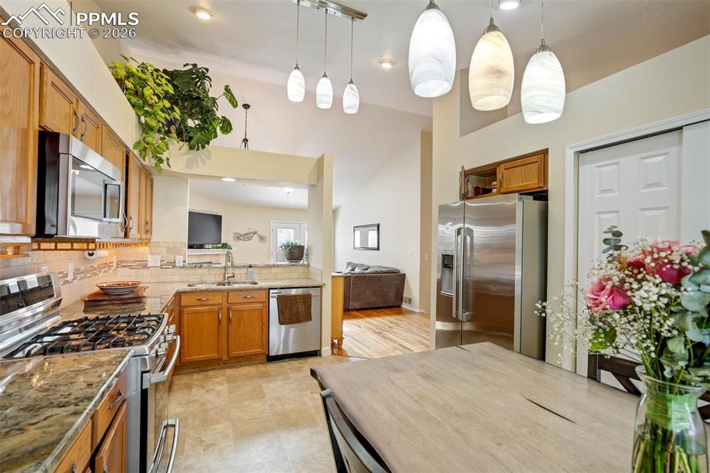 Image 11 of 50: The heart of the home features a bright, open-concept kitchen with warm woo