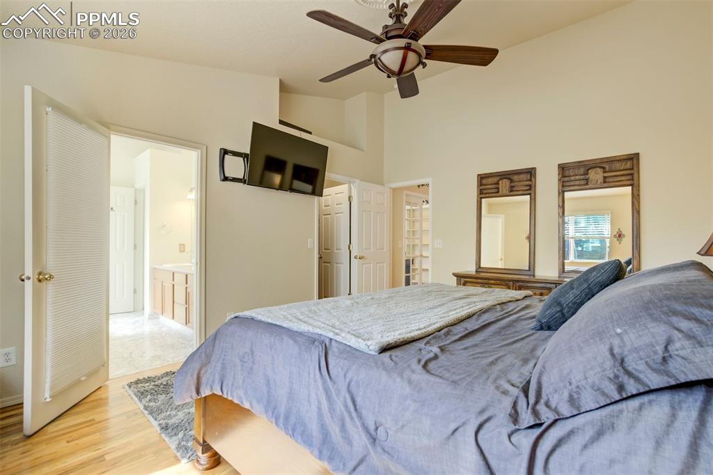 Image 24 of 50: Spacious primary bedroom featuring vaulted ceilings, hardwood floors, and a
