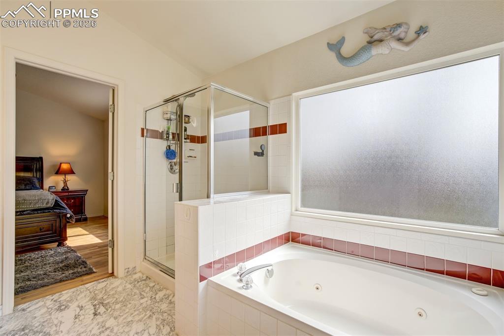 Image 27 of 50: Enjoy a spa-like experience with a soaking tub, separate glass-enclosed sho