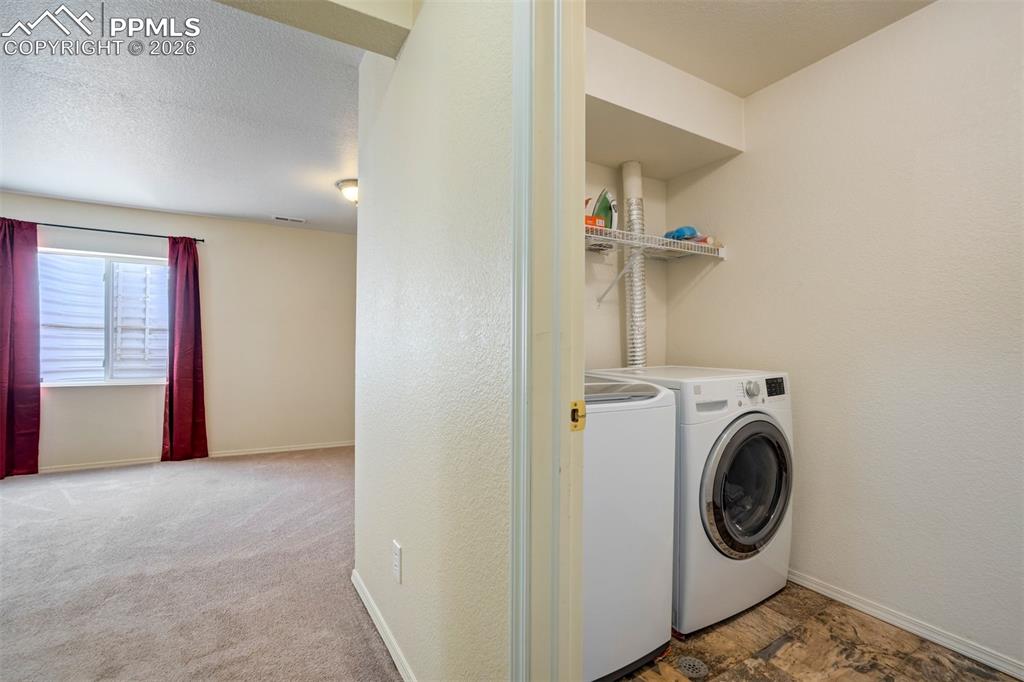 Image 34 of 50: Conveniently located laundry area with full-size washer and dryer, offering