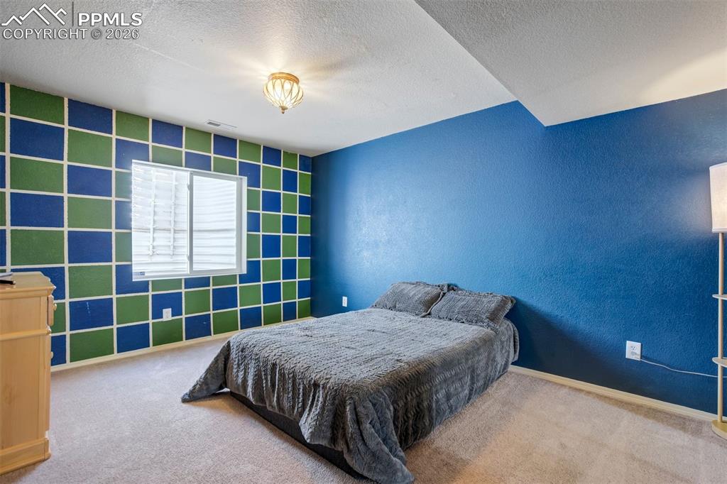 Image 35 of 50: Bright and cheerful, this bedroom features a large window and a unique geom