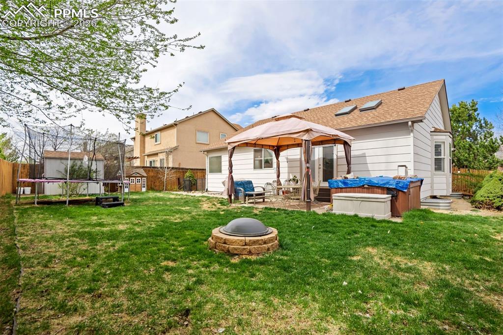 Image 45 of 50: Unwind in the backyard hot tub, offering a perfect place to relax year-roun