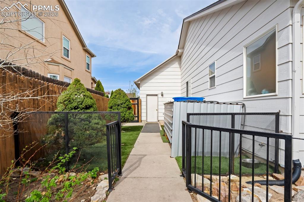 Image 47 of 50: The side yard provides a clean and functional walkway with gated access, id