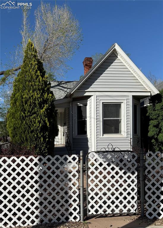 Caption: View of front of property featuring a gate, fence