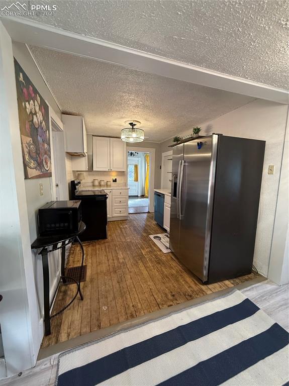Image 14 of 19: Kitchen with fridge, hardwood / wood-style flooring, dishwasher, light coun