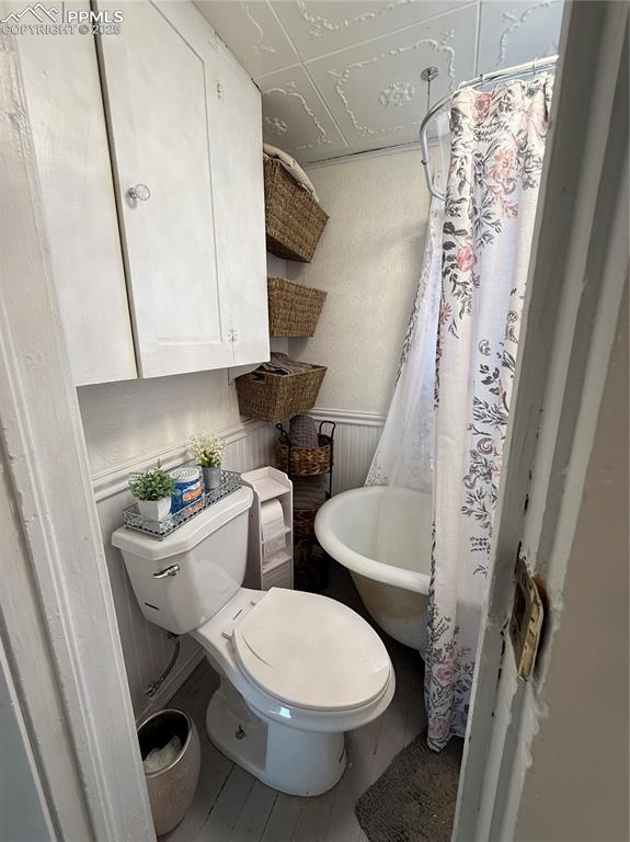 Image 7 of 19: Bathroom with a toilet, and a shower with curtain