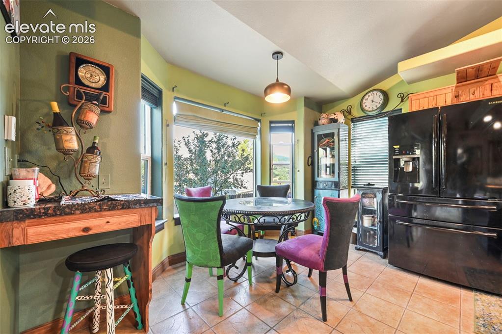 Image 10 of 43: Bay window dining area featuring tiled flooring and a contemporary pendant