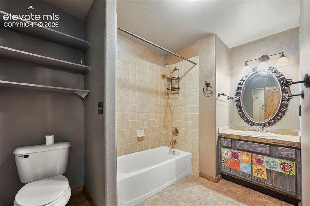 Image 27 of 43: Bathroom featuring a vanity with a decorative cabinet base, oval mirror, an