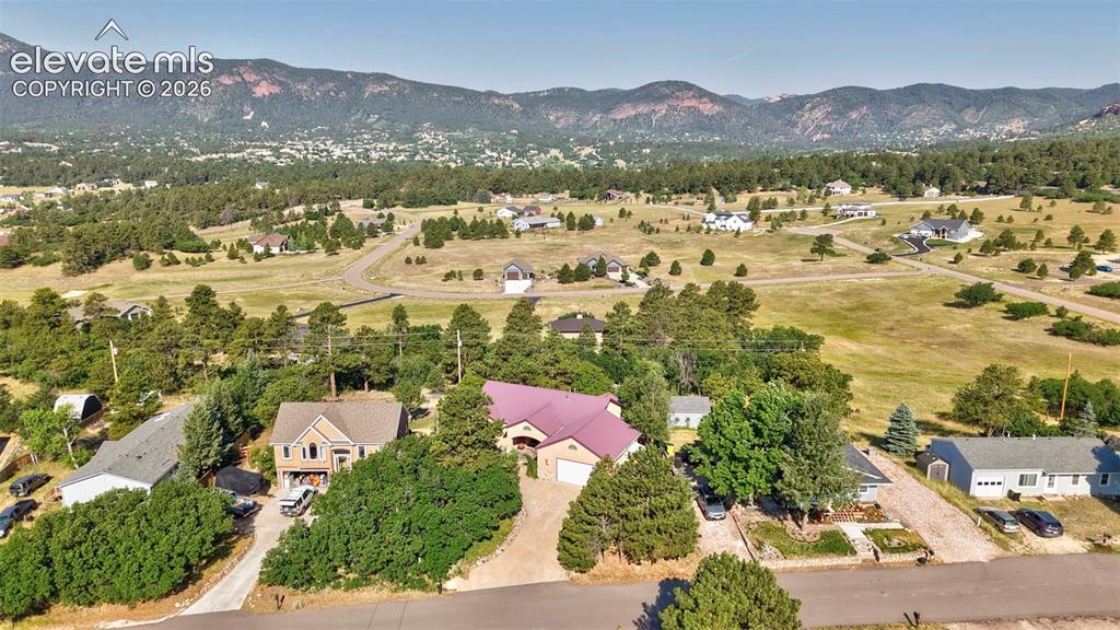 Image 3 of 43: Expansive property featuring a residence with a crimson roof, multiple matu