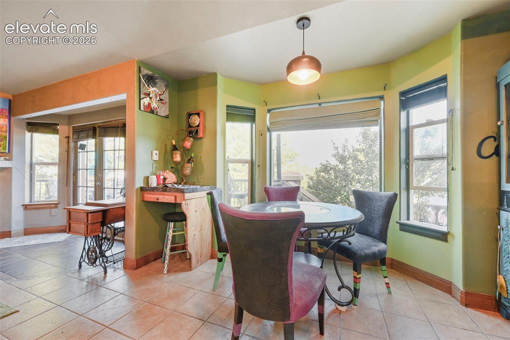 Image 9 of 43: Bay window dining area featuring multiple windows, a decorative pendant lig