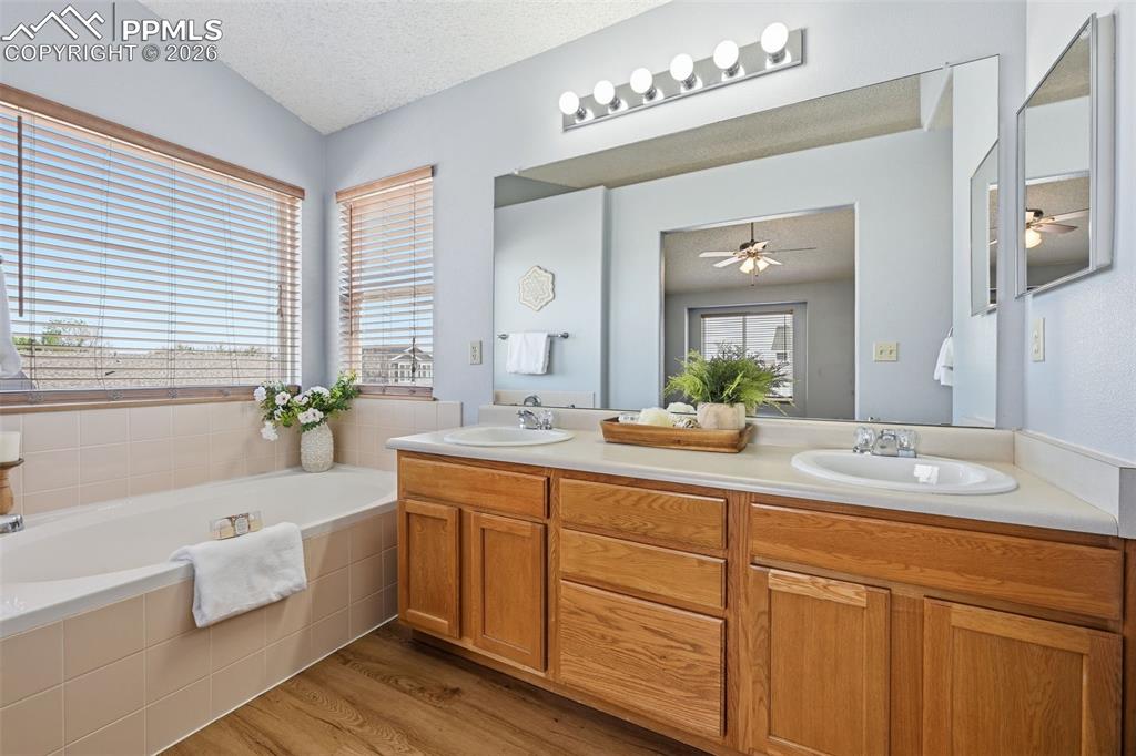 Image 18 of 42: Soaker tub, double sink, shower, and separate toilet room.