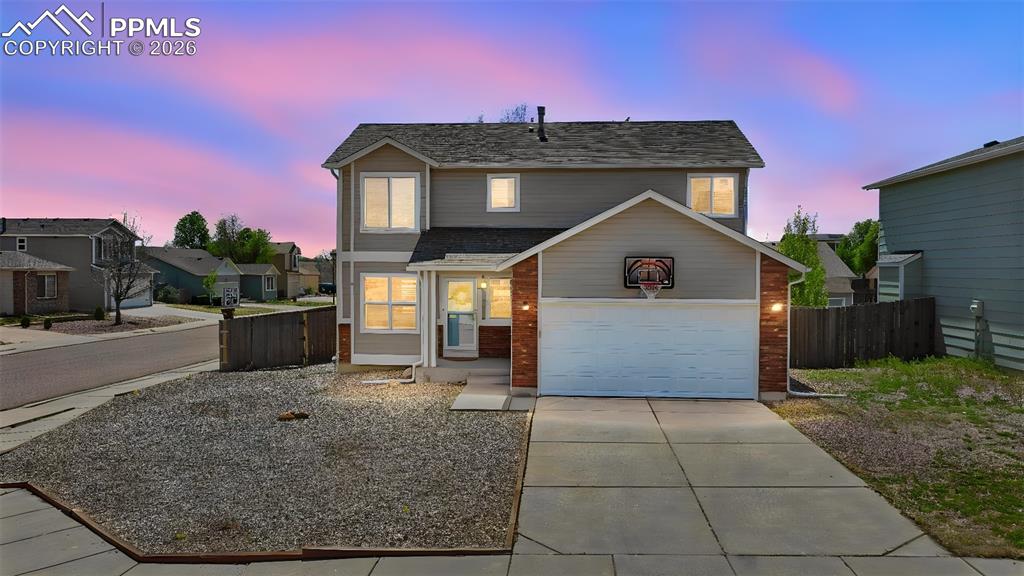 Image 3 of 42: Twilight view of home-Corner lot and fun basketball hoop for keeping active