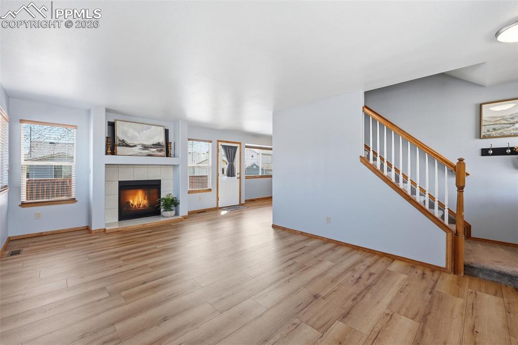 Image 38 of 42: View towards fireplace and dining area and stairs to upper level and 